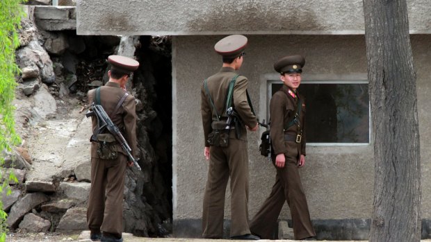 North Korean soldiers stand guard outside their post along the river bank of the North Korean town of Sinuiju, opposite the Chinese border city of Dandong in March.