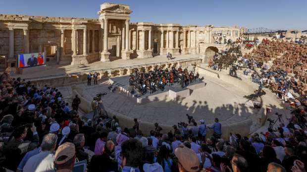 The concert in Palmyra, with the screen showing Vladimir Putin live via video link on the left.