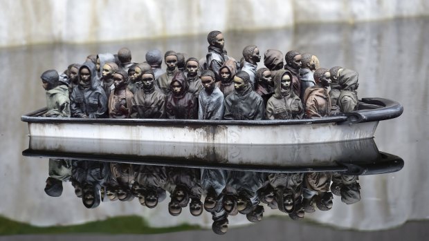 A Dismaland "water feature" includes this Banksy work depicting a boatload of immigrant figurines in the English Channel. 