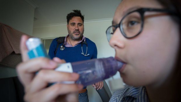 Asthma sufferer Angelique Harkins uses a spacer with her puffer, overseen by Dr Mark Hotu.