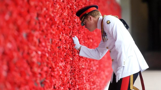 Prince Harry places a poppy at the Roll of Honour during a visit to the Australian War Memorial on Monday. 