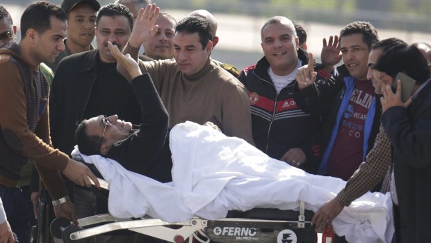 Former Egyptian dictator Hosni Mubarak acknowledges his supporters while returning to Maadi Military Hospital following his acquittal in Cairo on Saturday.