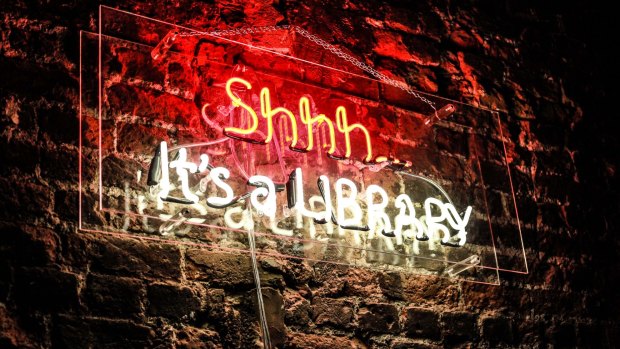 A neon sign glows on a wall of the Library private memberse' club in London.
