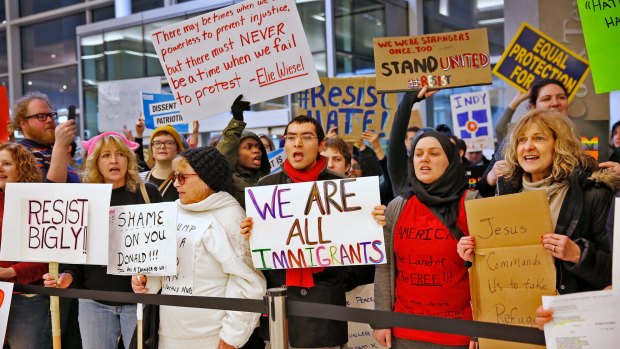 People chant slogans at the Indianapolis International Airport during a protest against President Donald Trump's executive order temporarily suspending all immigration for citizens of seven majority Muslim countries for 90 days.
