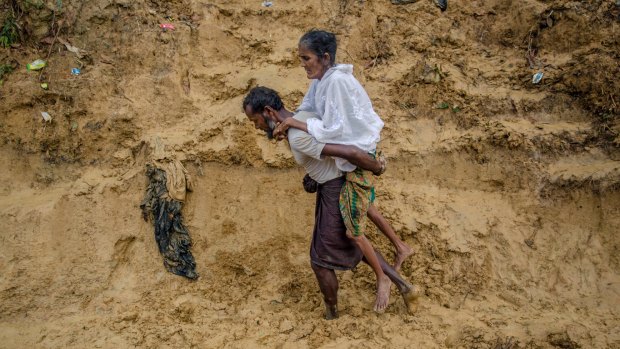 Alishaan, a recently arrived Rohingya Muslim man, carries his sick mother Aishya Khatoon to a hospital at Taiy Khali refugee camp in Bangladesh on Thursday.