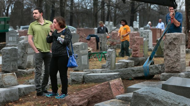 Sally Amon and her son Max Amon react to the toppled gravestone of her grandmother Anna Ida Hutkin at Chesed Shel Emeth Cemetery in St Louis, Missouri on Tuesday