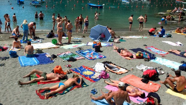 Tourists relax on a beach in the Cinque Terre.