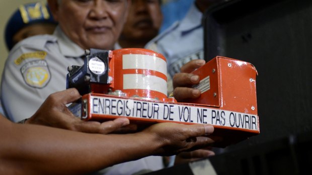 Head of Indonesian National Transportation Safety Committee Tatang Kurniadi, centre, shows the Cockpit Voice Recorder from the ill-fated AirAsia Flight 8501 in Pangkalan Bun, Indonesia.