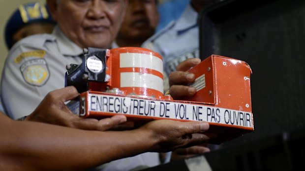 Head of Indonesian National Transportation Safety Committee Tatang Kurniadi, centre, shows the Cockpit Voice Recorder from the ill-fated AirAsia Flight 8501 in Pangkalan Bun, Indonesia.