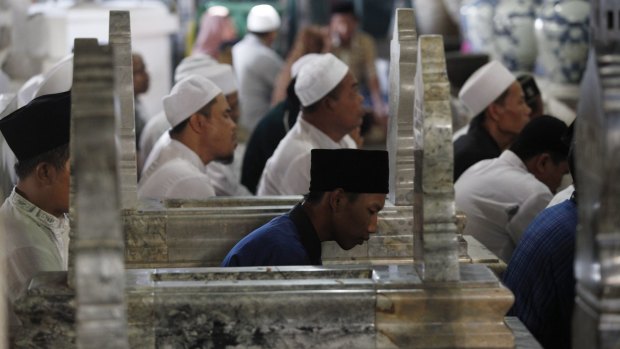 Indonesian Muslims pray between tombstones at the shrine of Sunan Gunungjati in Cirebon, West Java.