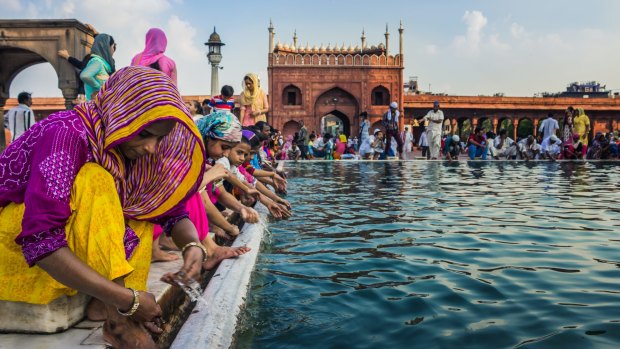 People wash themselves with water from an artificial pond at the premises of Jama Masjid, Delhi.