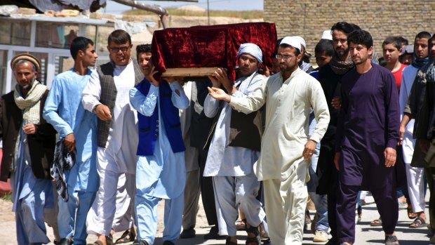 Men carry the coffin of one of the victims of Friday's attack at a military compound in Mazar-i-Sharif, northern Afghanistan.