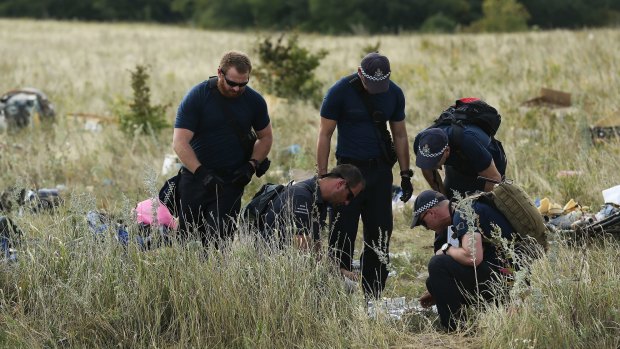 Australian Federal Police officers and their Dutch counterparts collect human remains from the MH17 crash site in the fields outside the village of Grabovka.