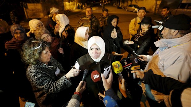 Residents talk to the media as Syrian Army soldiers stand nearby after an aid convoy entered Madaya on Monday.