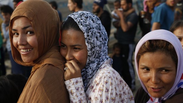 Migrant women wait in a line to get free tea at the border crossing of the northern Greek border point of Idomeni, Greece, on Tuesday.