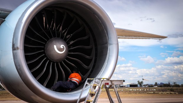 A worker tend to the engine of a grounded aircraft at Asia Pacific Aircraft Storage Facility near Alice Springs.