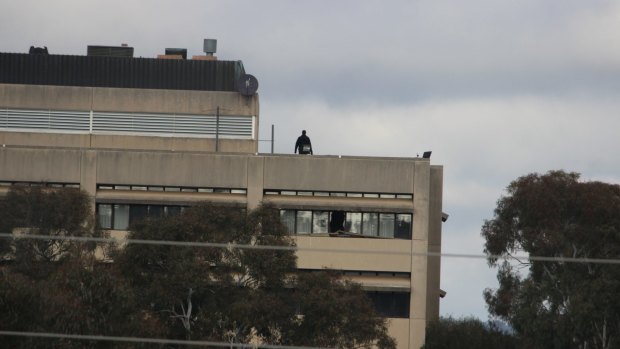 A police officer on the roof of the former CSIRO headquarters in Campbell on Saturday, May 27.