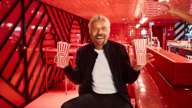Sir Richard Branson holds popcorn at Razzle Dazzle onboard his cruise ship, Scarlet Lady. 