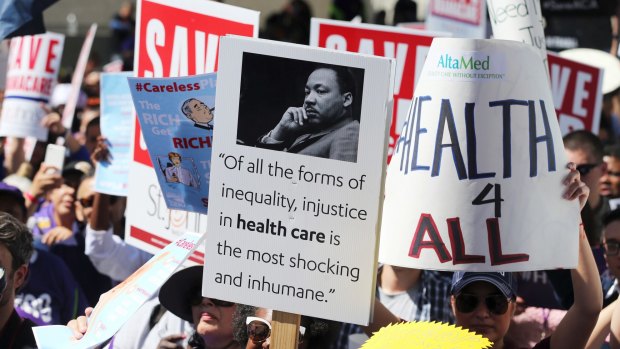 Hundreds of people march through downtown Los Angeles protesting Trump's plan to dismantle the Affordable Care Act.