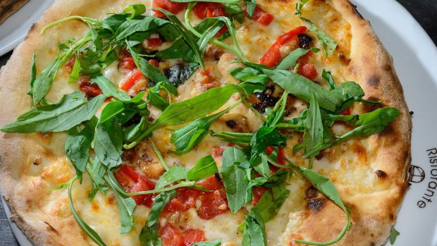 Homemade pizza with tomatoes and rocket