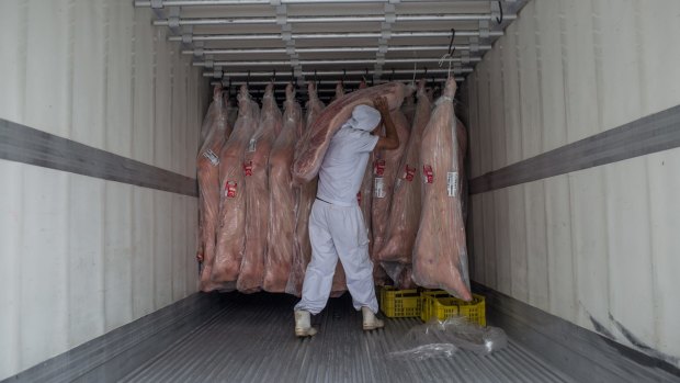 A butcher hangs meat in a container in Sao Paulo, Brazil.
