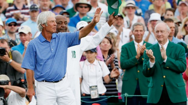 Ben Crenshaw waves to the gallery with his longtime caddie Carl Jackson behind the 18th green after playing his final Masters.