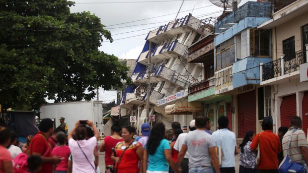 Residents look at a partially collapsed hotel in Matias Romero, Oaxaca state.