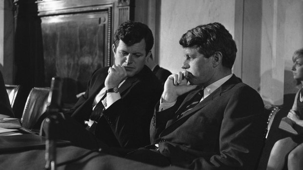 Edward Kennedy, who saw two brothers assassinated by guns, sits with Robert Kennedy in 1967.