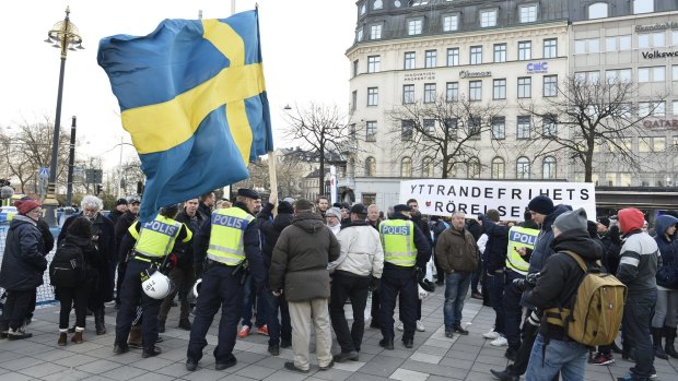 Police talk to demonstrators in Norrmalmstorg, a square in central Stockholm, on January 30.