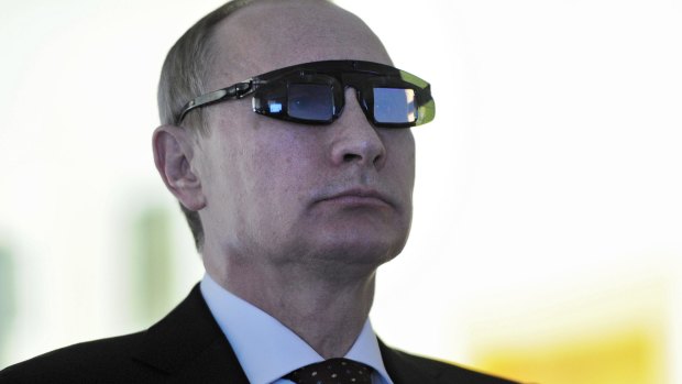Russian President Vladimir Putin wears special glasses at a research facility in St Petersburg