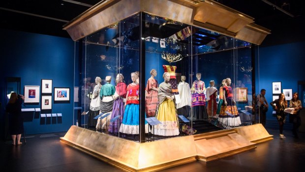 Visitors look at mexican traditional dresses owned by Frida Kahlo, part of the Frida Kahlo: Making Her Self Up exhibition, at the V&A, London.