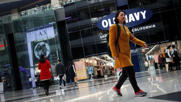 People walk near foreign brands fashion outlets at a shopping mall in Beijing. China is offering a reward for CHinese nationals to dob in foreign spies.