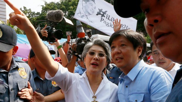 Children of the late Philippine dictator Ferdinand Marcos, former senator Ferdinand "Bongbong" Marcos jnr, centre right, and his younger sister Irene Marcos-Araneta arrive at the vigil to lend support to Marcos loyalists.