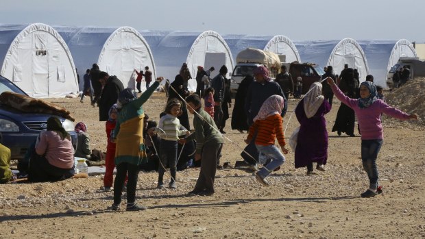 Displaced Syrian children play on Monday at a temporary refugee camp in northern Syria, near Bab al-Salameh border crossing with Turkey.