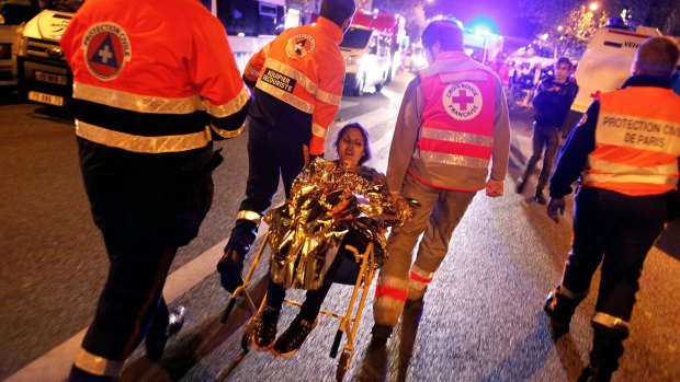 A person is being evacuated after a shooting, outside the Bataclan in Paris.