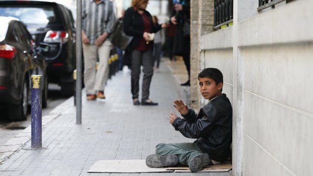 A Syrian boy sits on a footpath as he begs for money in Beirut.