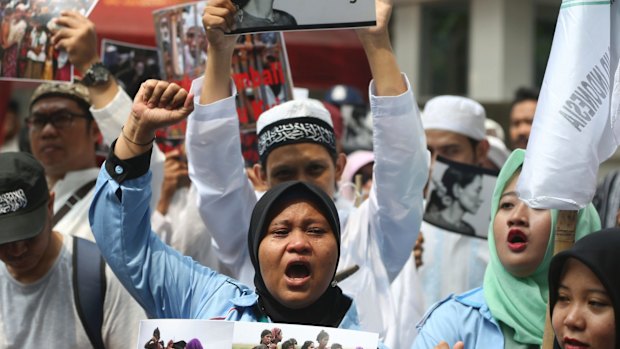 Indonesian activists hold poster during a protest in front of the Myanmar Embassy in Jakarta, Indonesia.