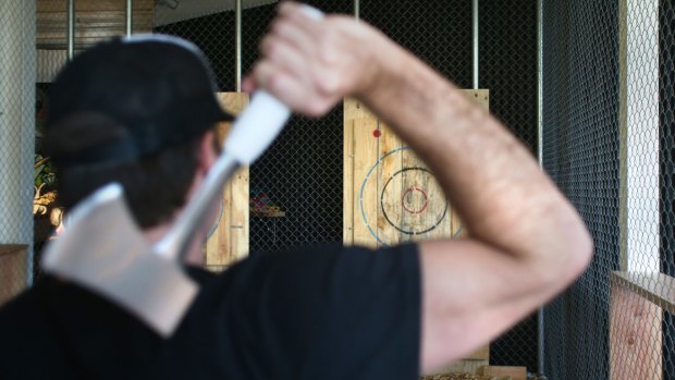 Adam Schilling, co-owner of Maniax, gets ready to throw an axe at one of the targets.