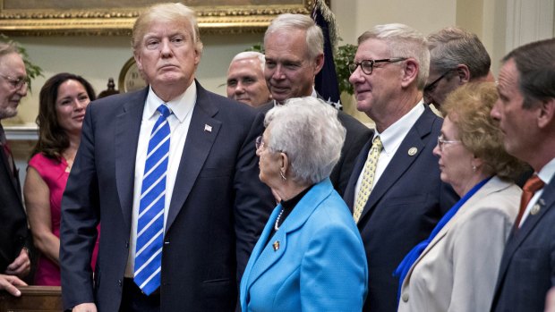 Donald Trump stands after signing four bills to nullify some education measures put in place during the Obama administration.