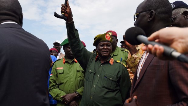 Lieutenant-General Simon Gatwech Dual (hand raised) greets supporters at Juba airport on Monday.
