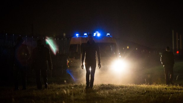 Police direct men away from the Eurotunnel terminal on Monday.