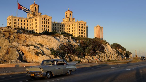 One of Havana's many classic 1950s cars drives past former Mob-owned Hotel Nacional.