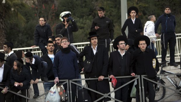 Ultra orthodox Jews stand at the scene of an attack in Jerusalem.