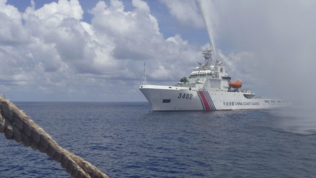 Tensions: A Chinese Coast Guard vessel sprays a water cannon at Filipino fishermen near Scarborough Shoal last year. 