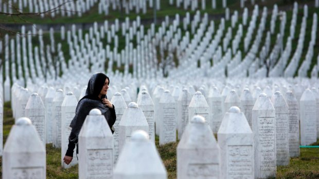 A Bosnian woman walks among gravestones at Memorial Centre Potocari near Srebrenica, Bosnia and Herzegovina.