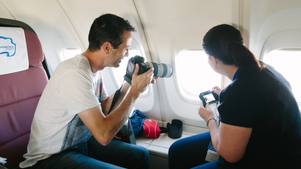 Passengers ready their cameras to snap photos as the plane flies over Antartica.