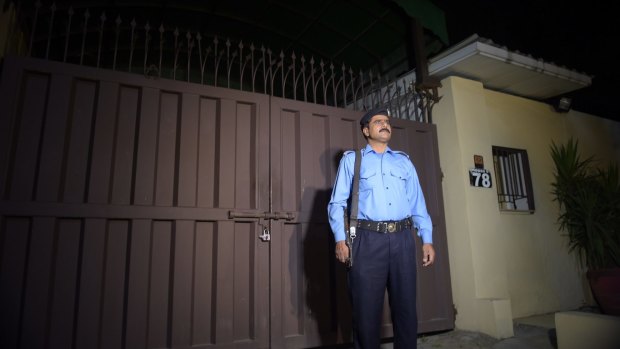 A Pakistani policeman stands guard outside the Islamabad office of the international charity Save the Children, which was sealed by order of Pakistani authorities on June 11.