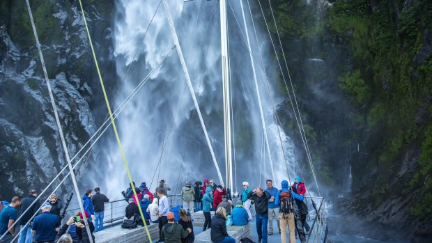 Passengers on the Mariner drink in one of Milford Sound's spectacular waterfalls.