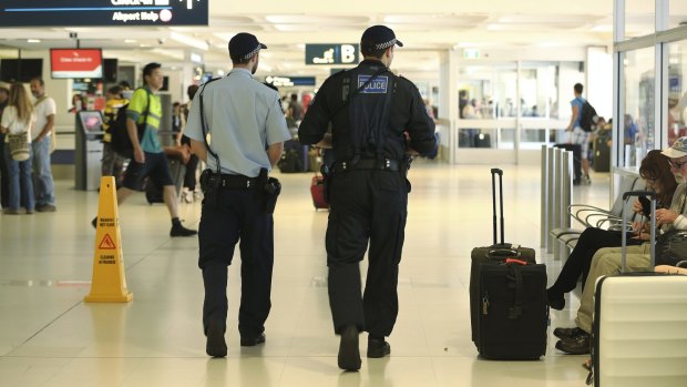 AFP officers patrol the departures area of Sydney International airport.