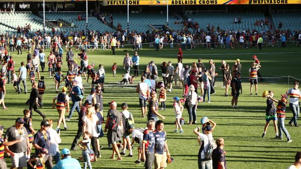 Spectators play kick and catch on the ground after the match between Adelaide and Fremantle.